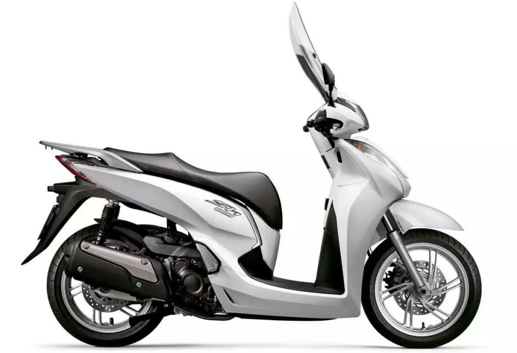 Foto lateral de uma SH 300i 2023 branca, a scooter esta estacionada dentro de um estudio