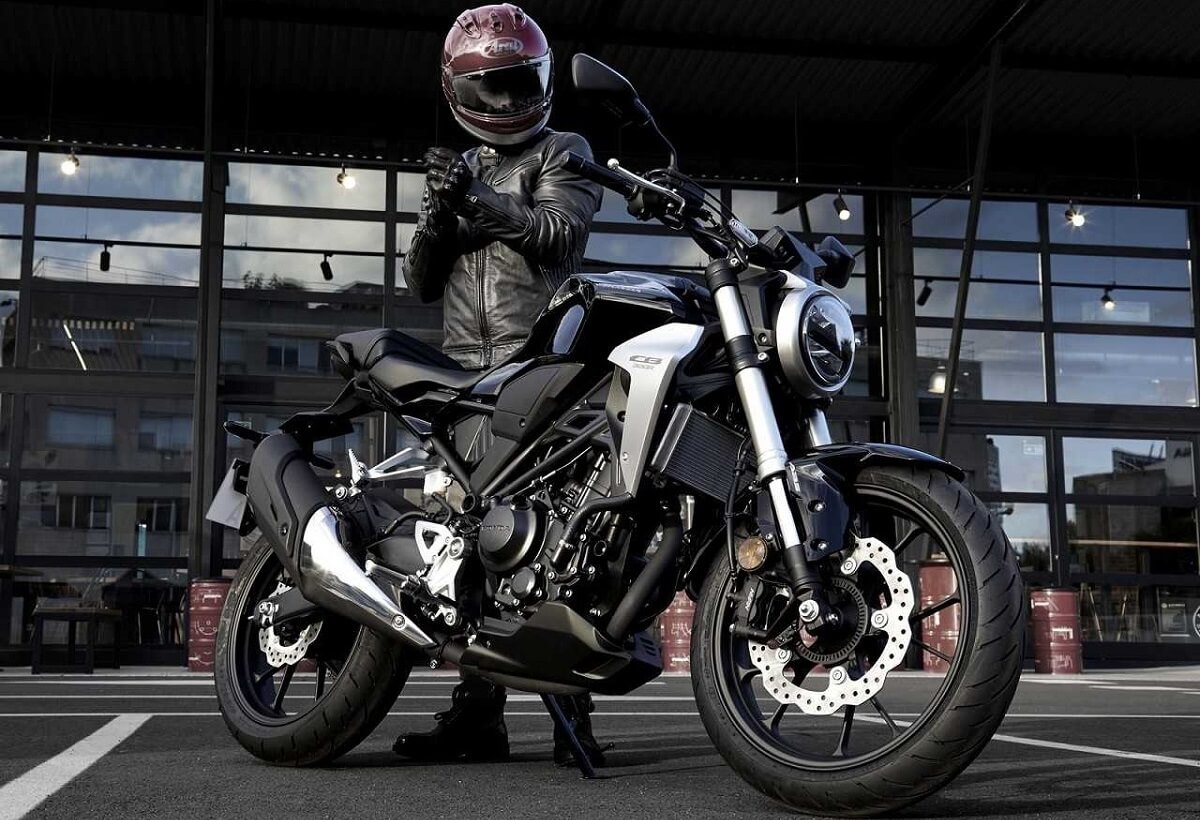 Foto de uma pessoa ao lado de uma CB 300 2023 preta