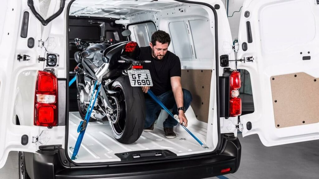 Foto de uma pessoa amarrando uma moto dentro de um Jumpy 2023