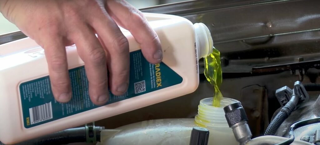 Foto colocando o aditivo para radiador.