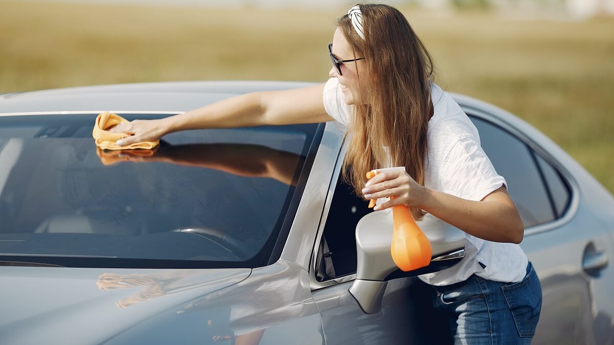 mulher higienizando os vidros do veiculo