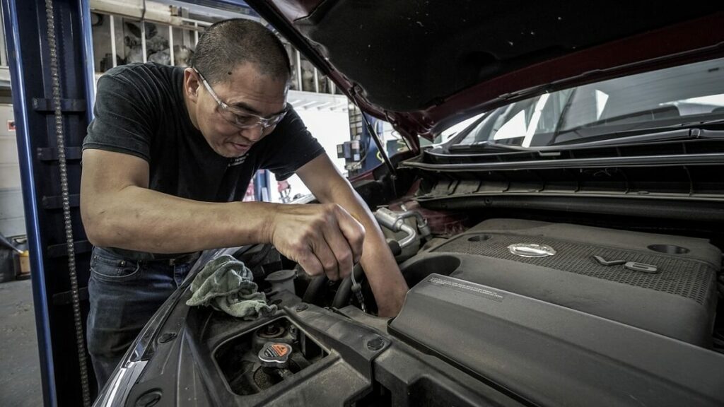 Homem verificando motor de partida a frio