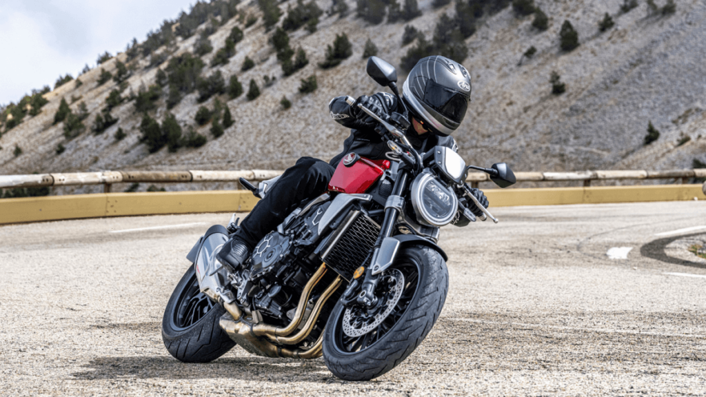 Foto de uma pessoa andando em uma CB 1000R 2023 vermelha