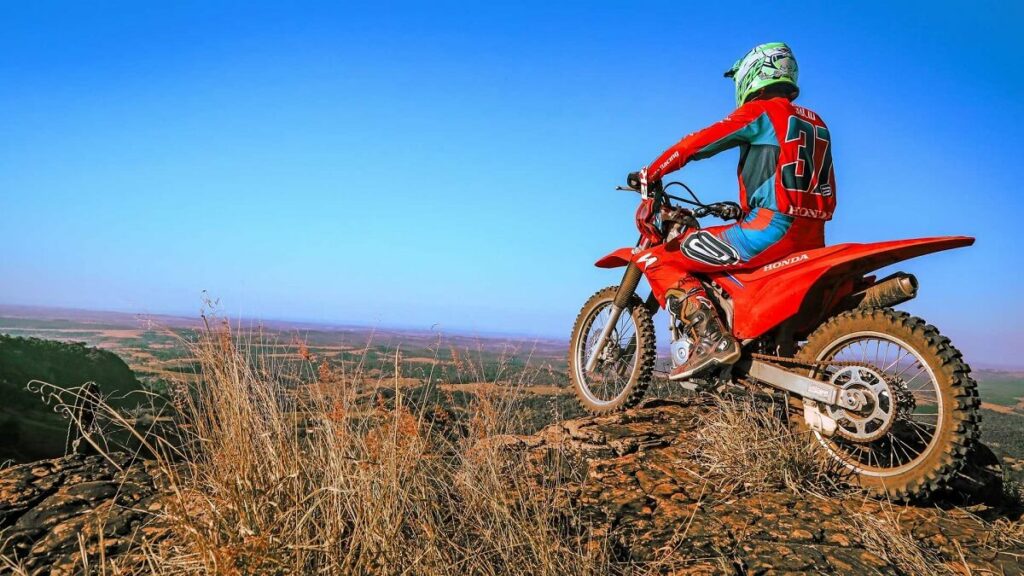 Moto trail em cina de um morro.