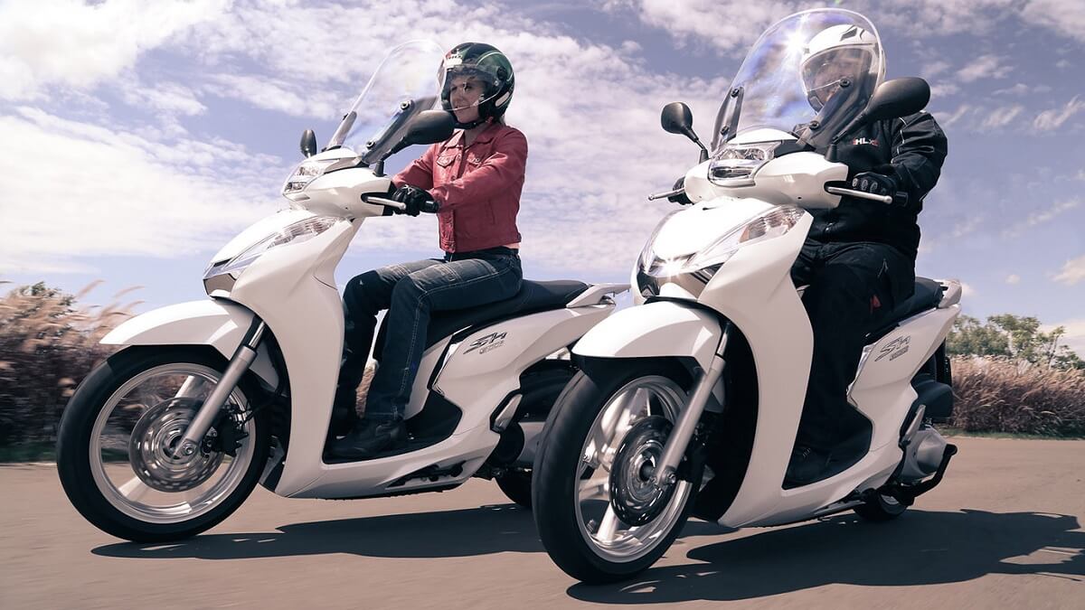 Foto de duas SH 300i 2023 sendo pilotadas, a moto conta com a cor branca