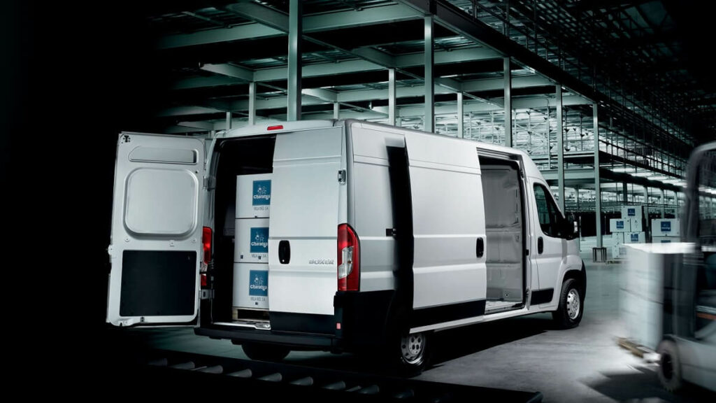 Foto de uma Peugeot Boxer 2023 com as portas traseiras e lateral aberta.