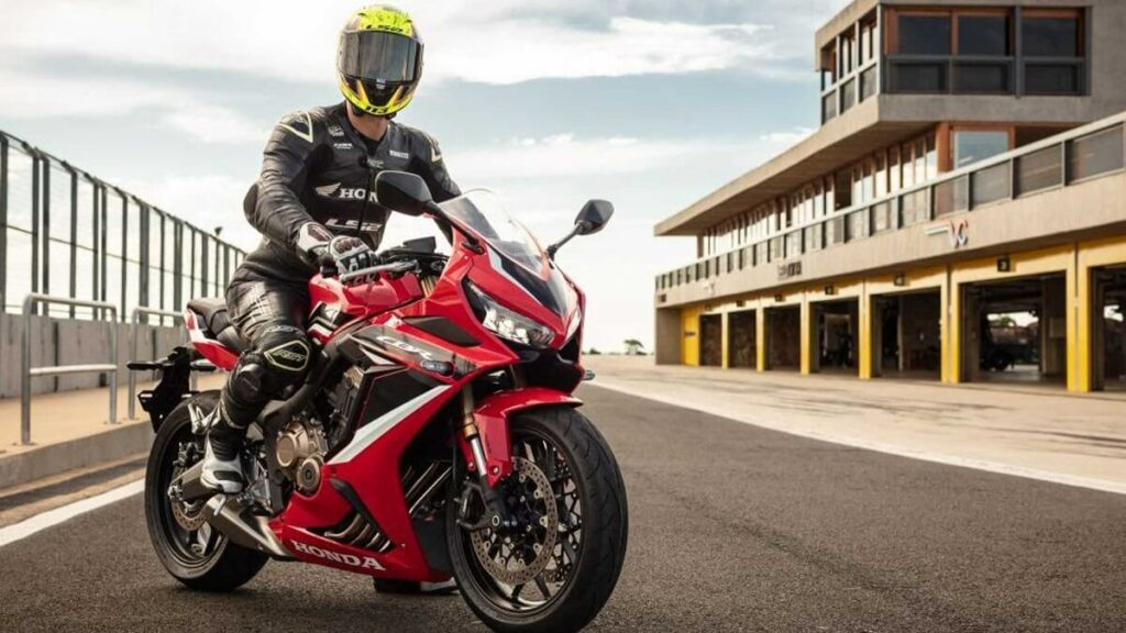 Foto de uma pessoa montada em cima de uma CBR 650 R 2023 vermelha