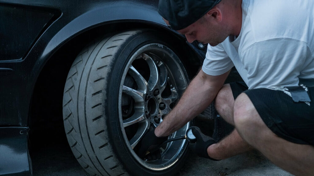 Foto homem fazendo a conferencia da calibragem do pneu
