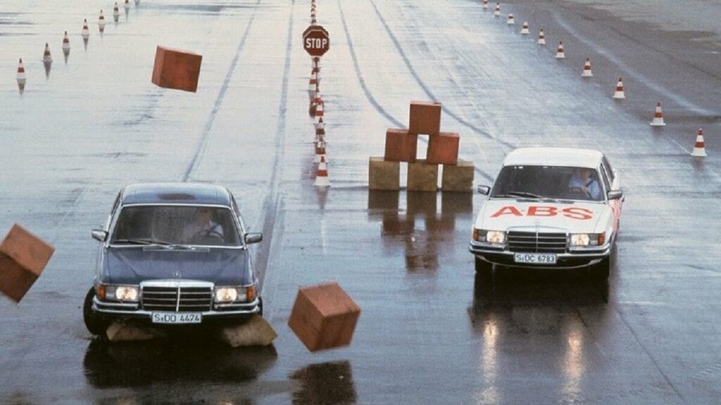 Dois carros realizando testes de frenagem, primeiros testes com Freio ABS, em uma pista molhada e com obstáculos.
