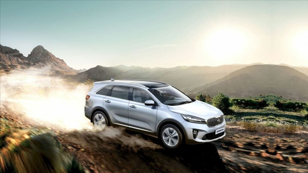 Foto de um Sorento andando na estrada de chão