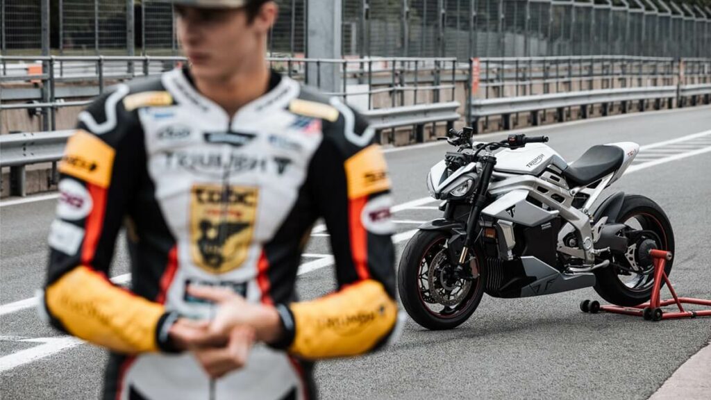 Foto do piloto entrevistado e da moto TE-1 de fundo