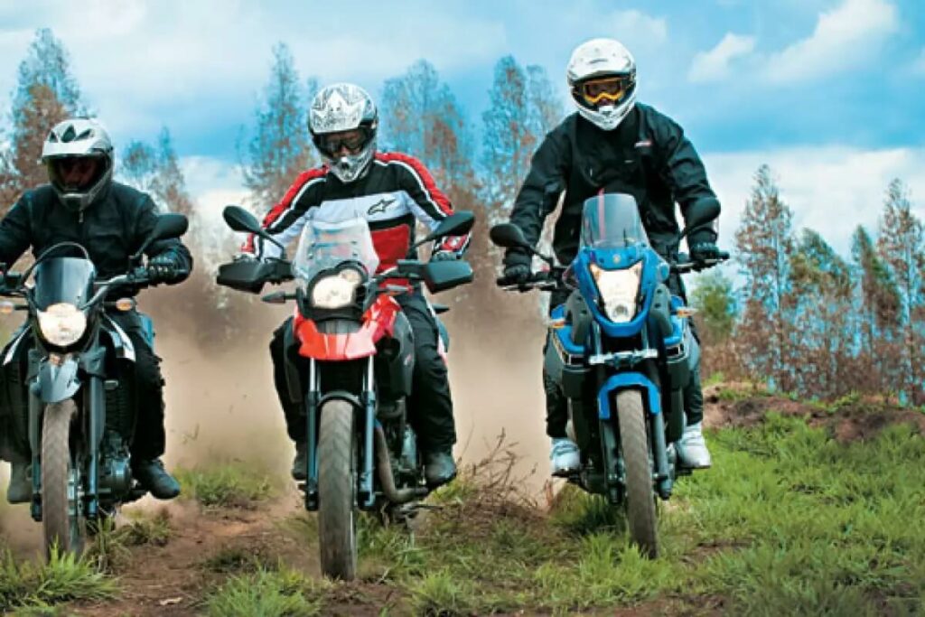 Foto de três pessoas andando em de moto, a moto é uma XT 660 2023