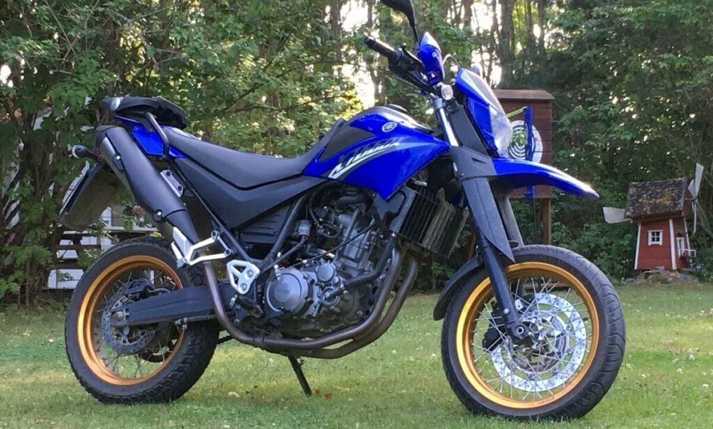 Foto lateral de uma XT 660 2023 azul estacionada na grama