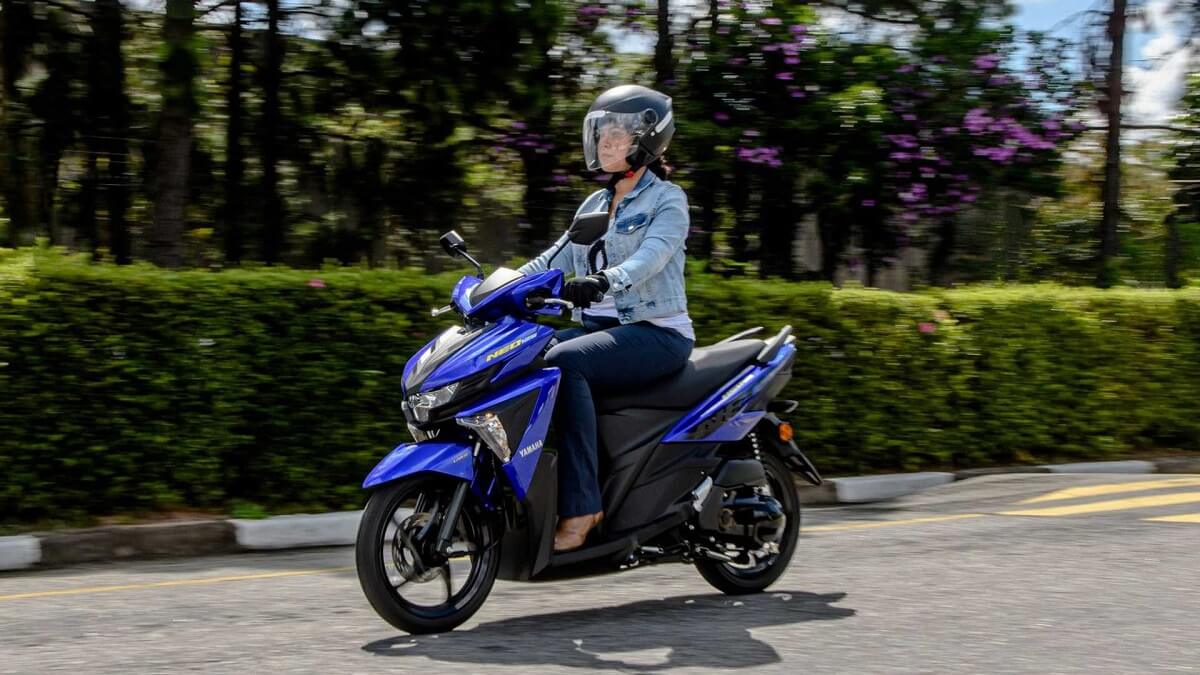 Foto de uma mulher pilotando uma NEO 2023 azul, a mulher esta em uma rua