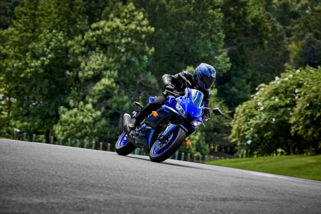 Foto de uma pessoa andando em uma estrada com uma R-3 2023 azul