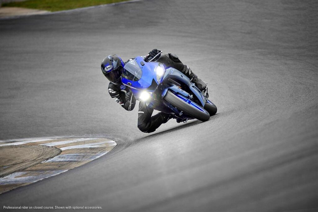 Foto de uma pessoa fazendo uma curva com uma R-3 dentro de uma pista de motovelocidade