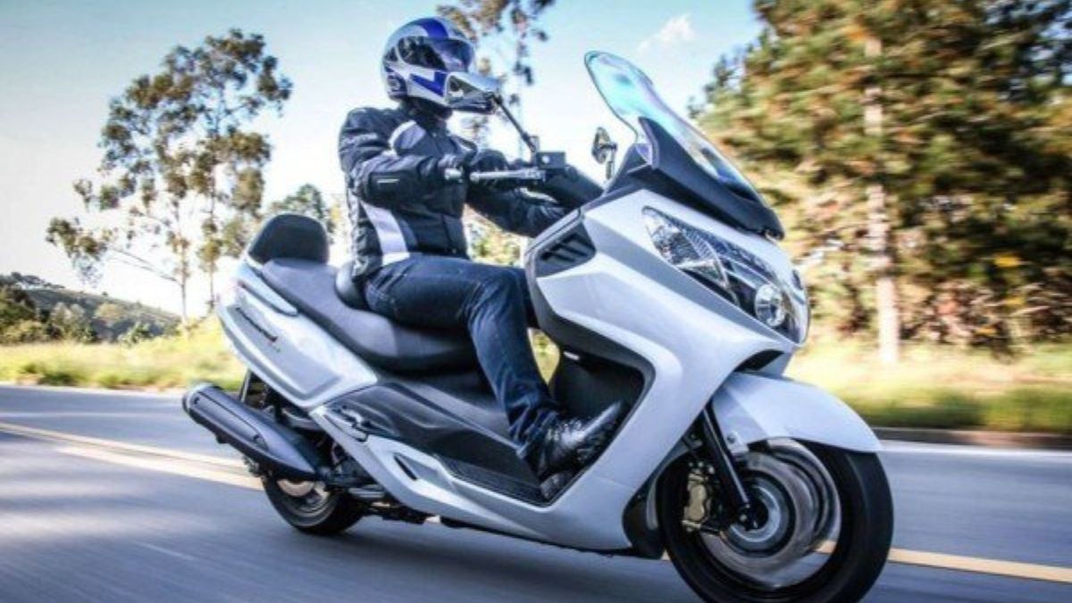 Scooter Maxsym 400i branca sendo pilotada na estrada.