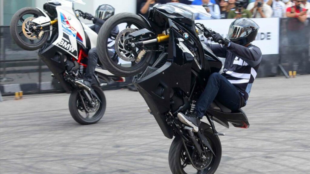 Homens empinado a BMW G 310 RR 2023.