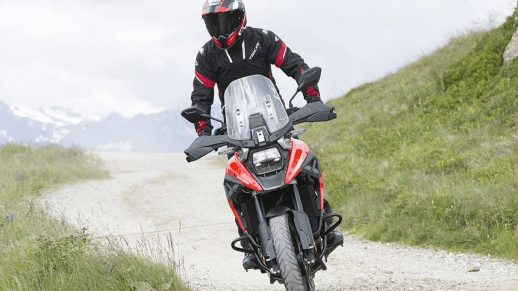 Piloto em pé na moto.