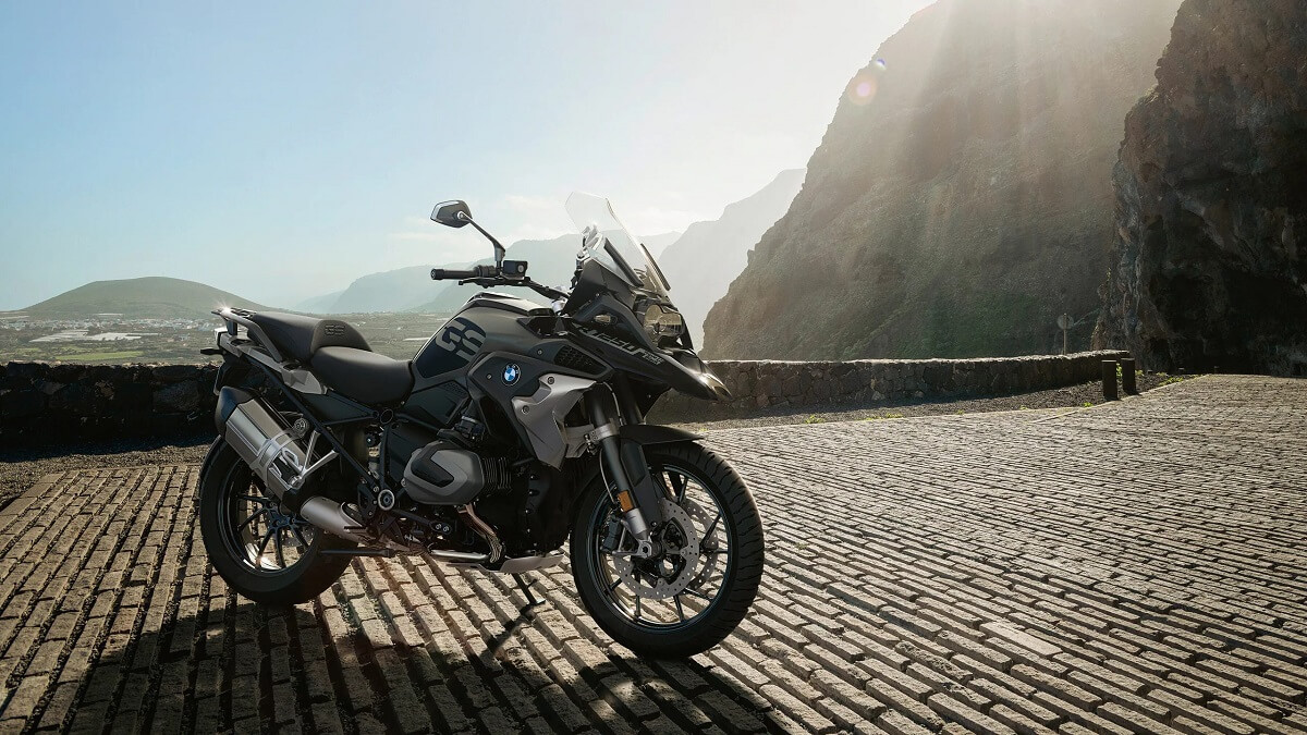 Foto lateral de uma BMW R 1250 GS 2023 preta, o modelo esta estacionado em um pátio