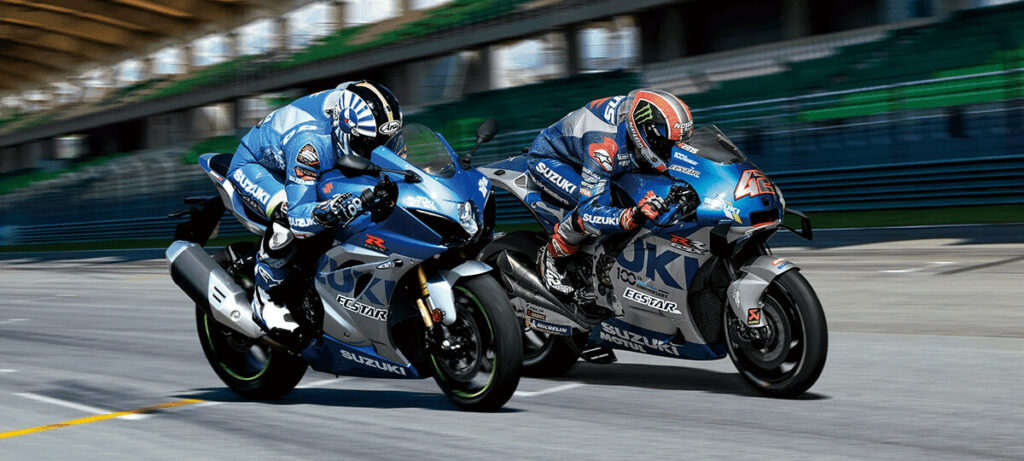 Dois pilotos em uma pista de corrida, com motos.