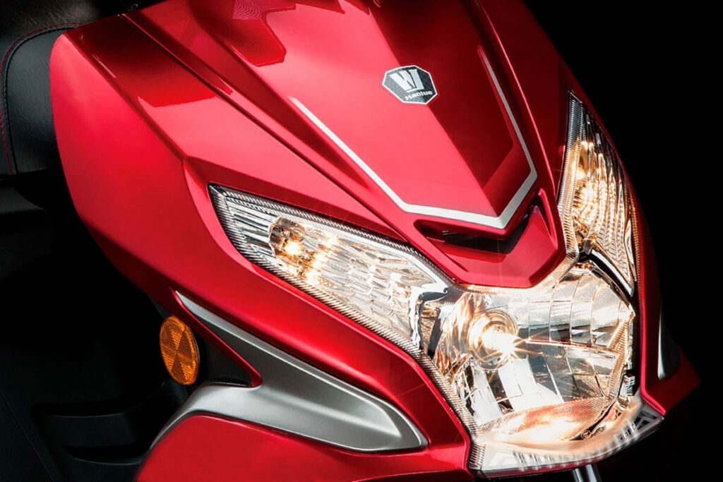 Foto frontal de uma VR 150 2023 vermelha, foco no farol da moto