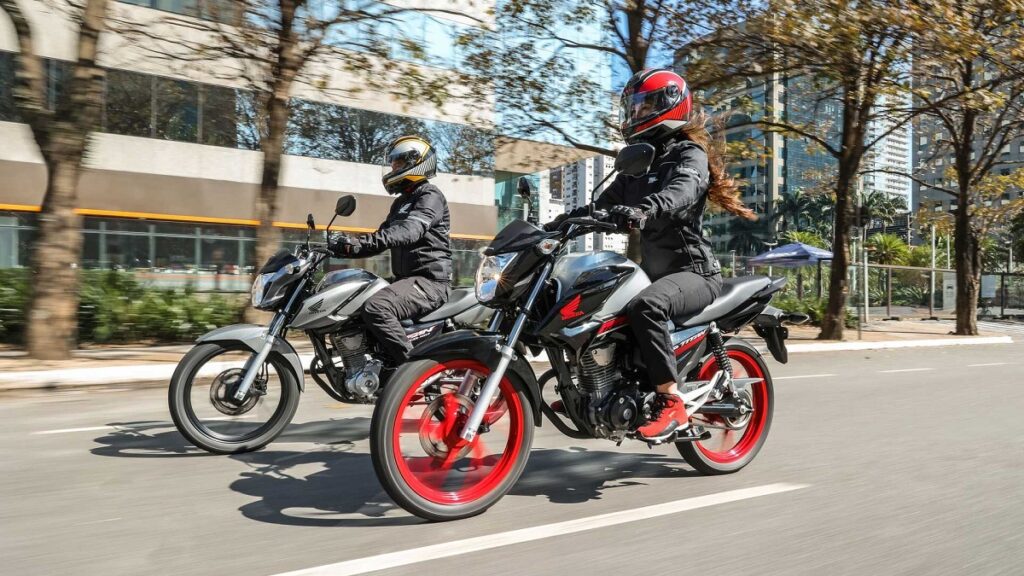 Foto de duas CG 160 2023 sendo pilotadas em uma rua, um dos modelos mais furtados