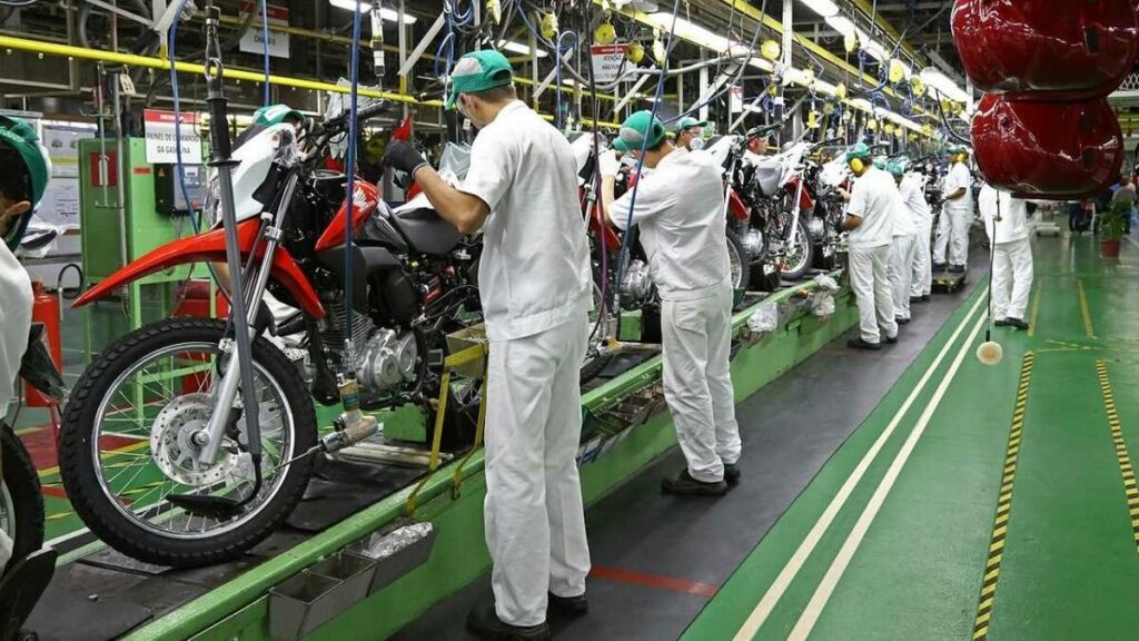 Foto de pessoas trabalhando em uma fabrica de produção de motos