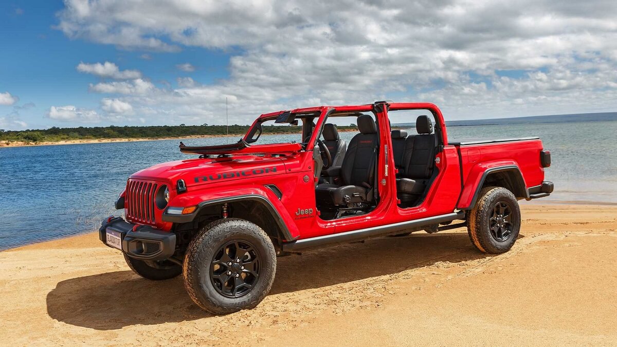 Foto lateral de uma Jeep Gladiator 2023 vermelha em uma praia