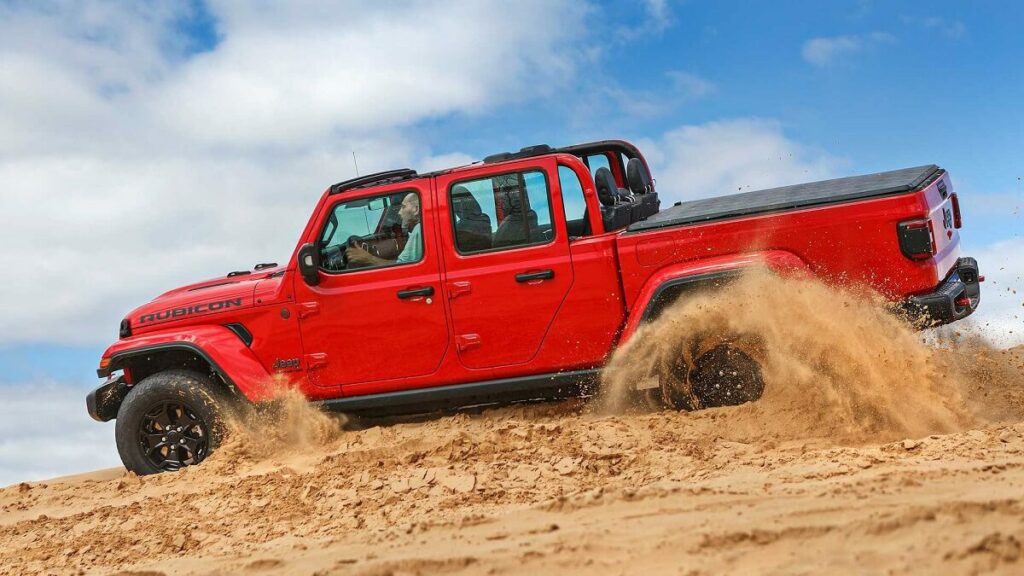 Foto lateral de um Jeep Gladiator 2023 andando na areia