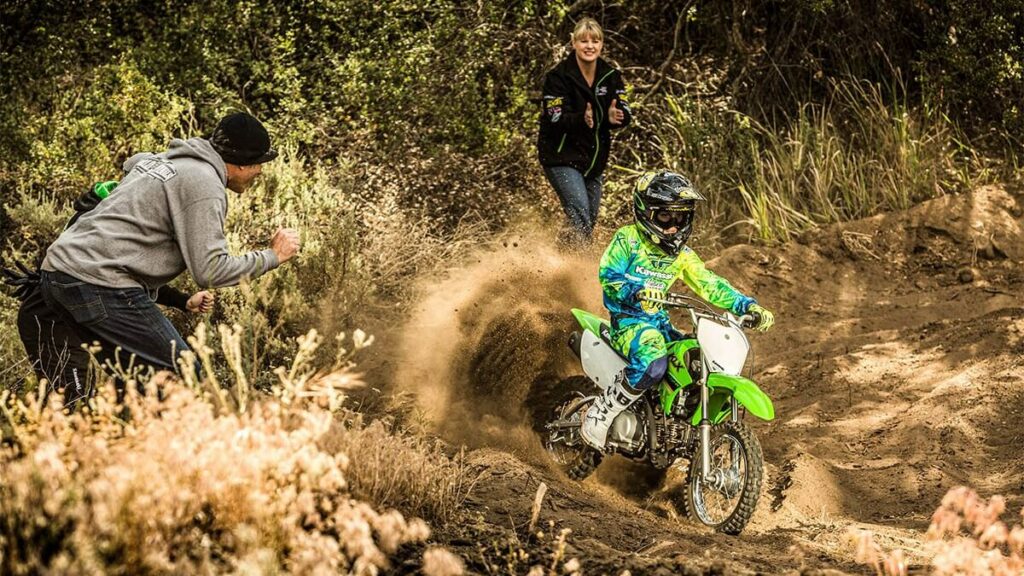 Criança fazendo uma trilha off-road com a moto.