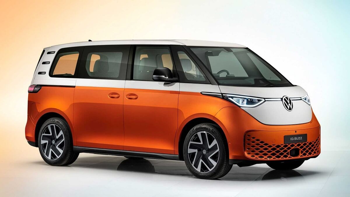 Foto lateral de uma Kombi elétrica laranja com branco