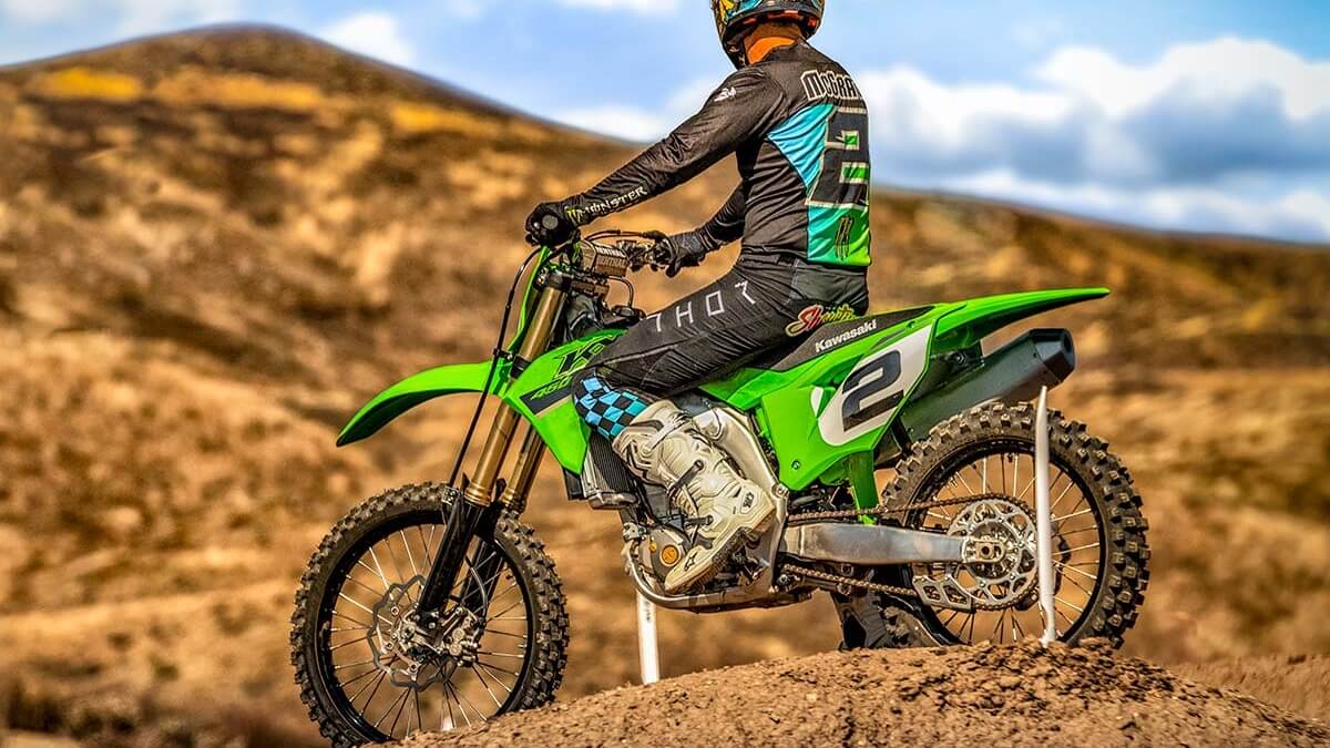 Homem parado em cima da KX 450.