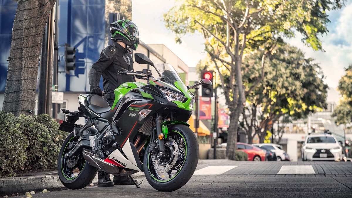 Homem com uma ninja 650 2023 estacionada.
