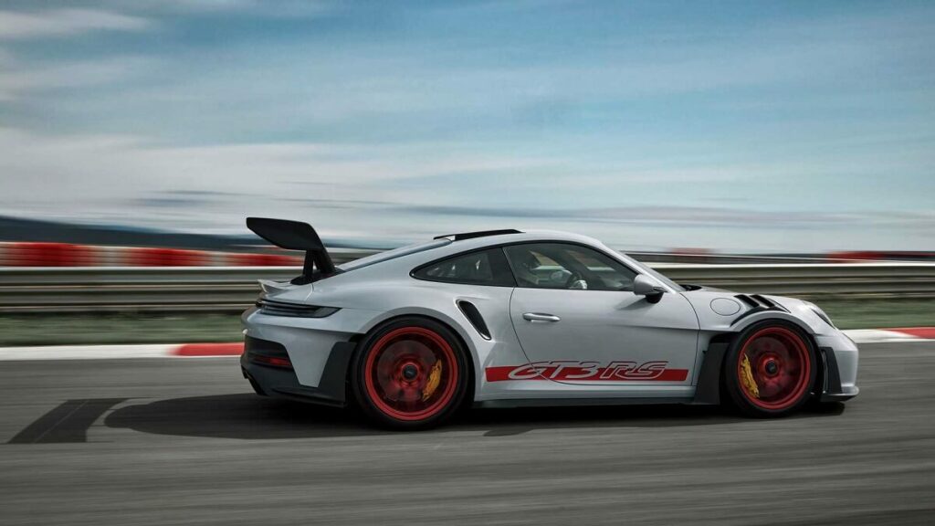 Foto lateral de um esportivo Porsche 911 GT3 RS 2023 branco andando em um autódromo