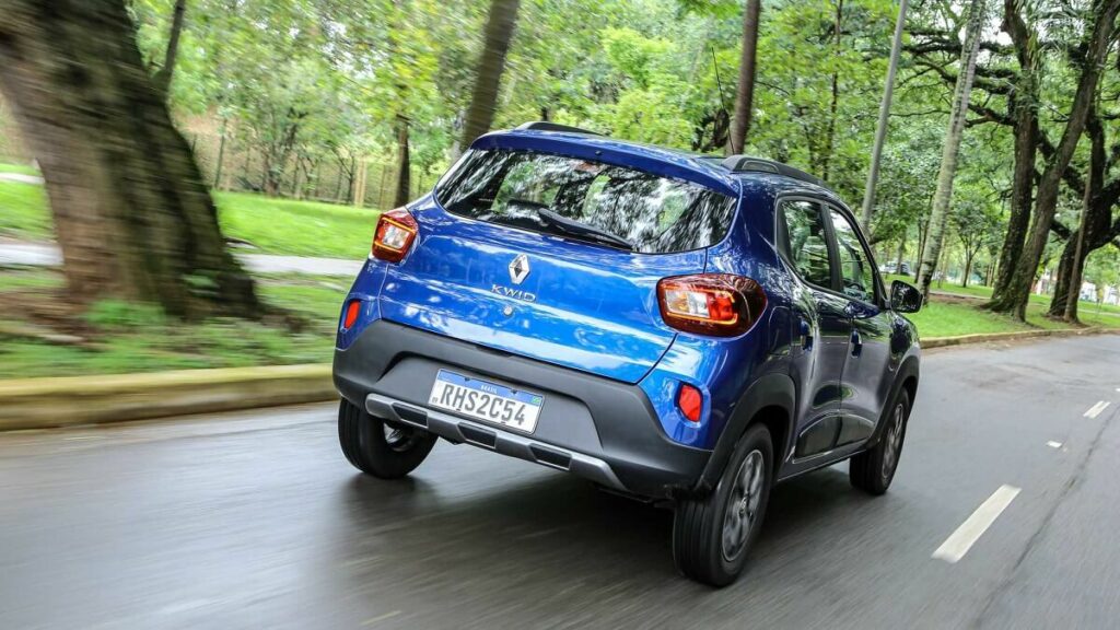 Foto traseira de uma Kwid Outsider azul andando na estrada