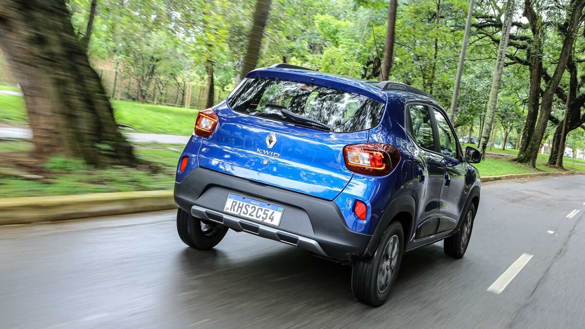 Foto traseira de uma Kwid Outsider azul andando na estrada