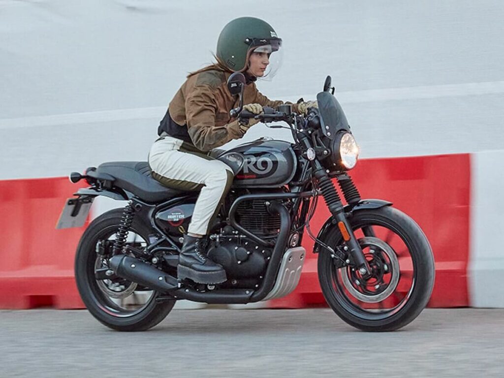 Foto de uma pessoa andando com uma Hunter 350 em uma rua