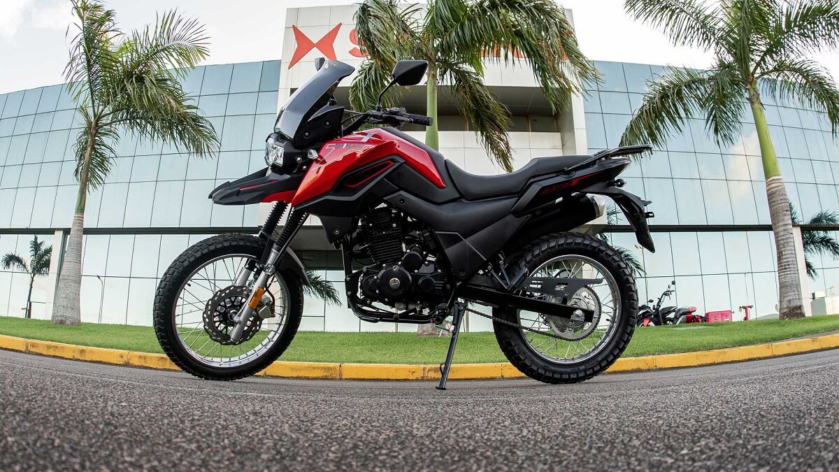 Foto lateral de uma Shi 175 2023 vermelha em frente a uma montadora da Shineray