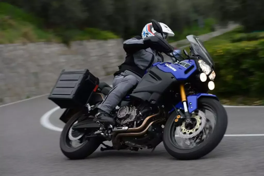 Foto de uma pessoa fazendo uma curva com uma Super Ténéré 2023 azul