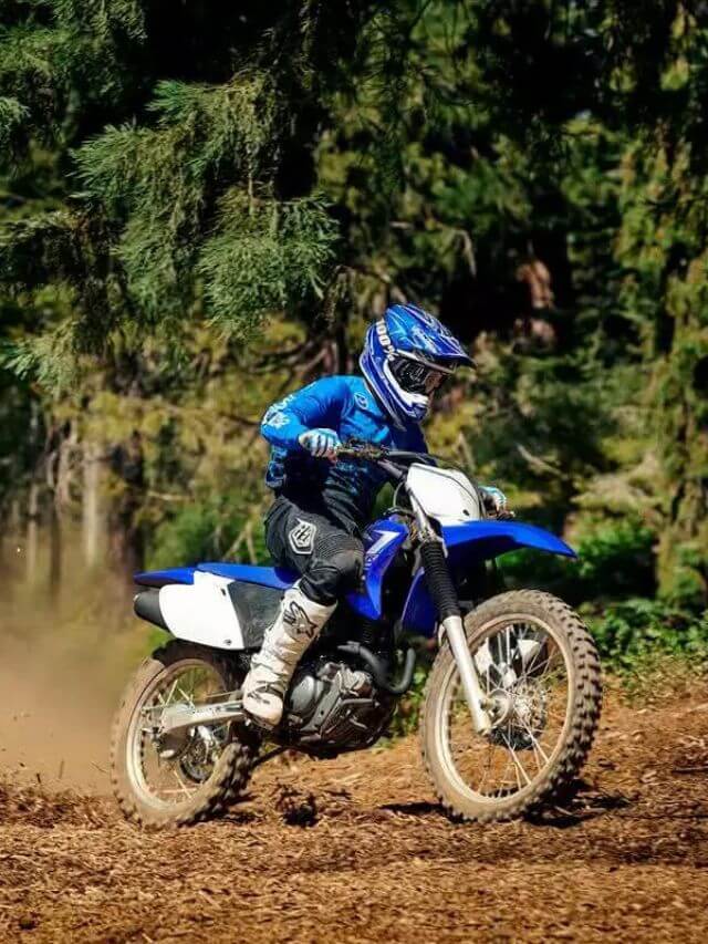 Homem fazendo uma trilha com uma Yamaha TT-R azul.