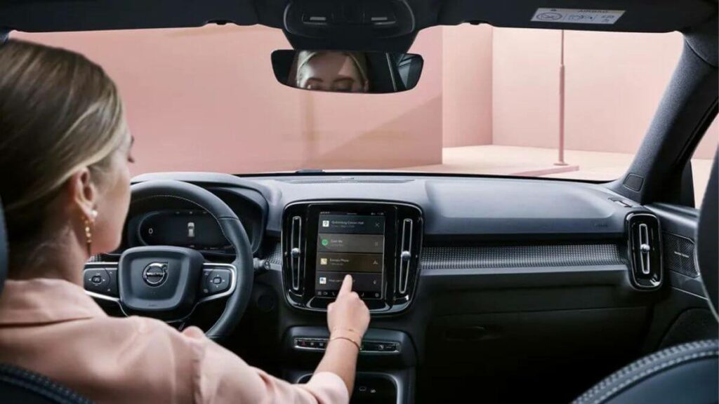 Mulher mexendo no painel do Volvo XC40 2023.