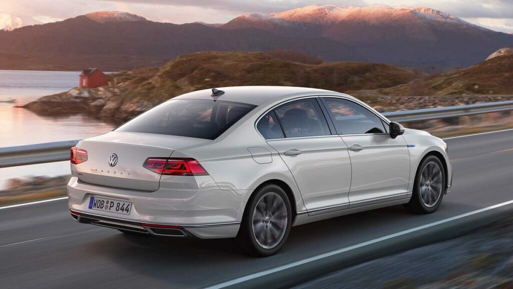 Foto da traseira de um Passat em 2023, o carro esta andando em uma estrada