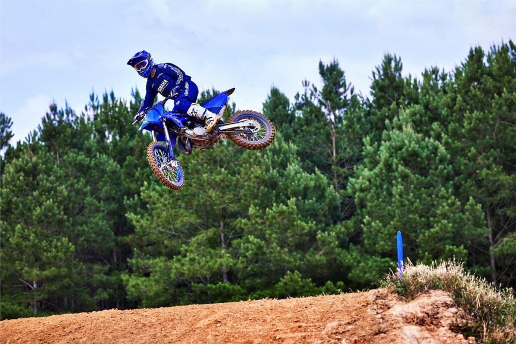 Foto de uma pessoa saltando bem alto com uma YZ 85 LW 2023 azul da Yamaha