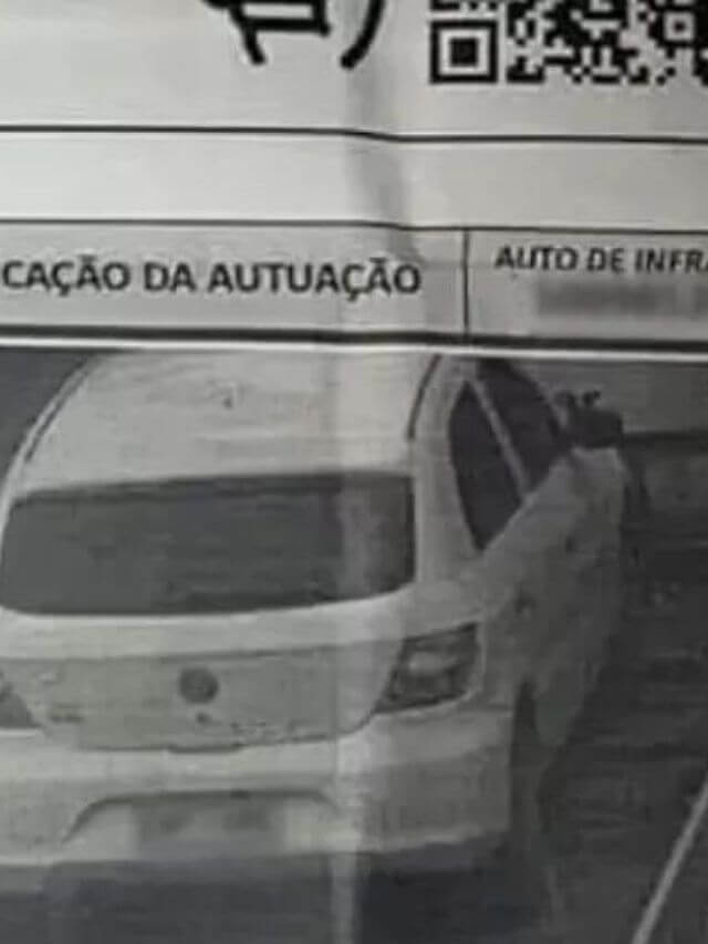 Carro sendo multado em cima de um guincho,