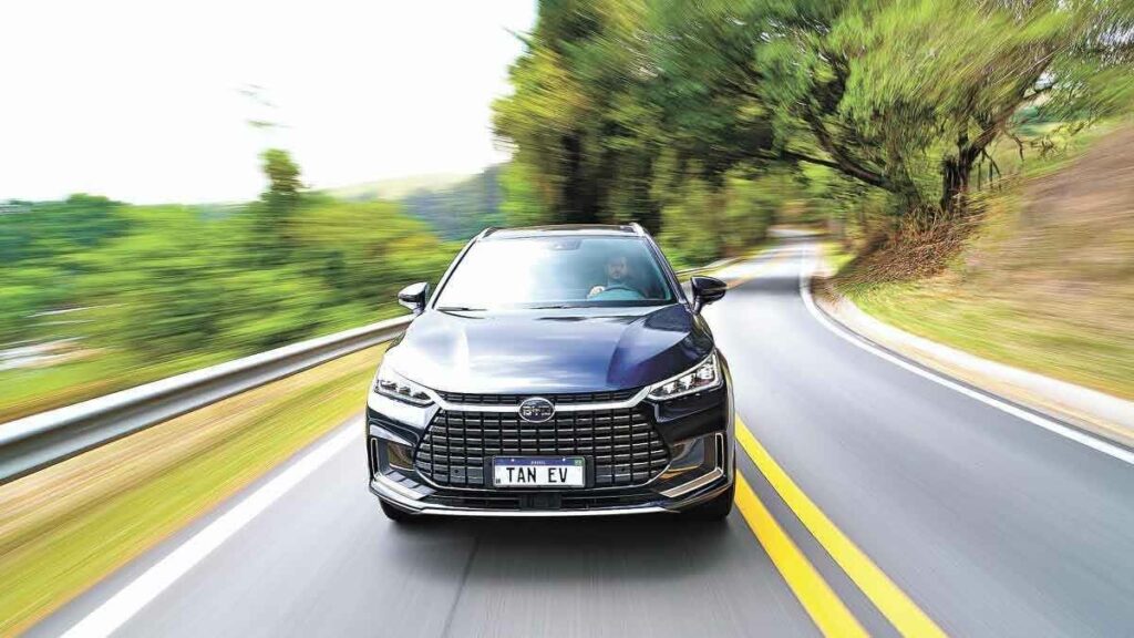 Foto frontal de um BYD Tan 2023 andando em uma estrada