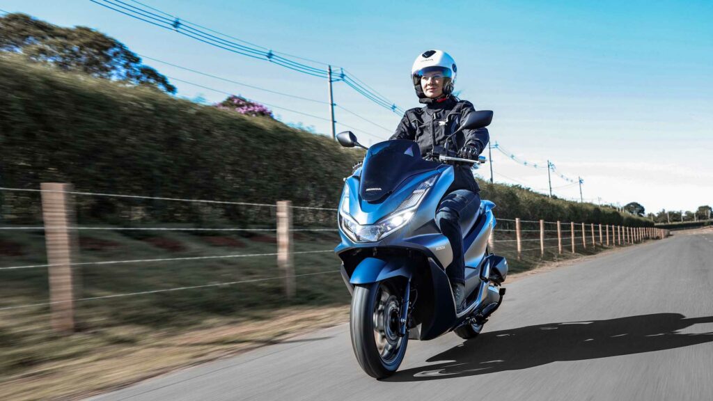 Foto de uma pessoa andando com uma Honda PCX 160 2023