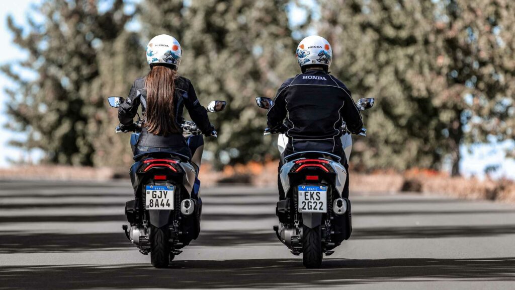 Foto de duas pessoas andando com uma PCX 160 2023