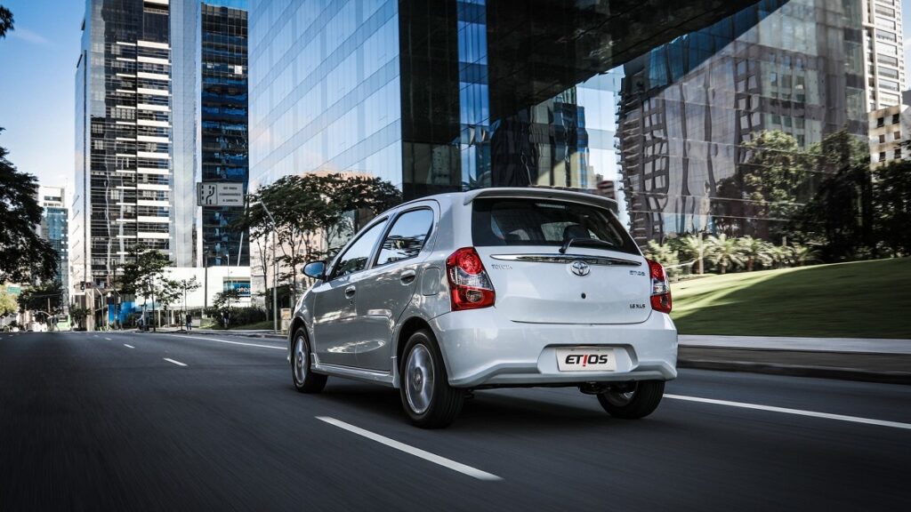 Foto da traseira do Etios em 2023, que está andando em uma rua na cidade