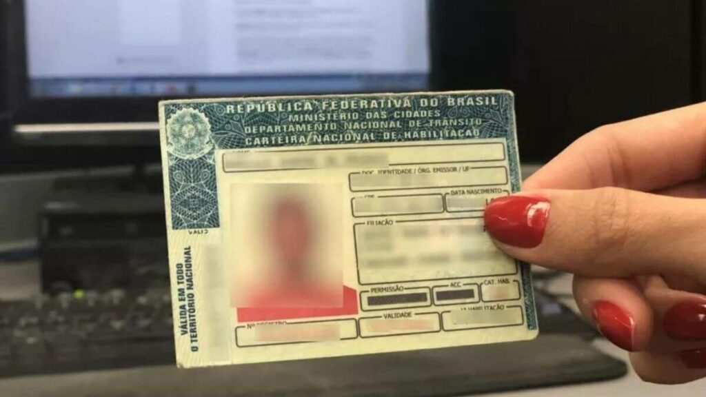 Mulher segurando uma CNH.